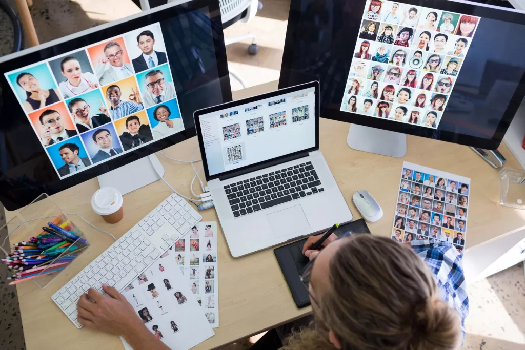 Male executive working over laptop and graphic tablet at his desk in office